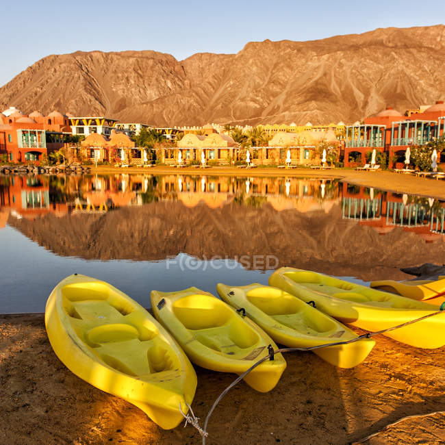 Vista panorámica de barcos amarillos en la playa, casas en el fondo - foto de stock