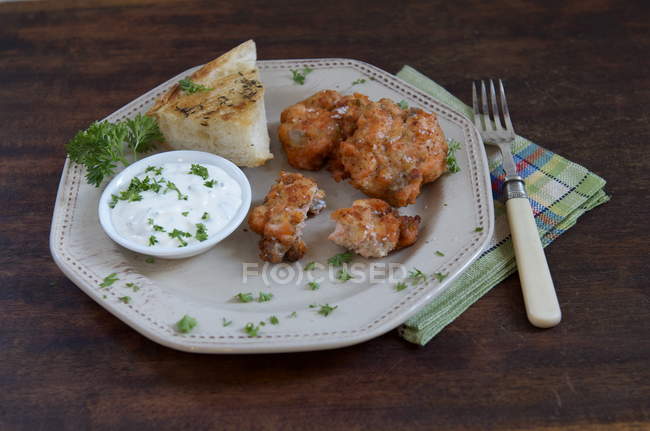 Prato de bolos de salmão, molho e pão na placa na mesa de madeira — Fotografia de Stock
