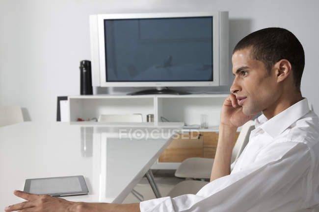 Visão lateral do empresário no telefone no escritório com tablet — Fotografia de Stock