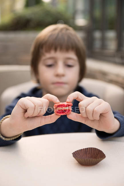 Close-up of Boy holding half eaten macaroon — Stock Photo
