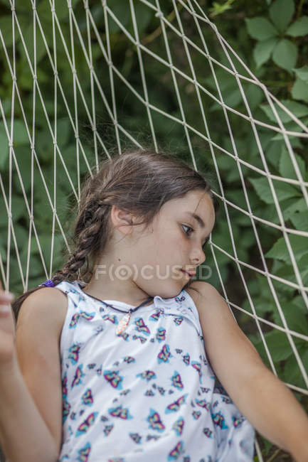Nachdenkliches Mädchen, das auf Hängematte im Freien liegt — Stockfoto