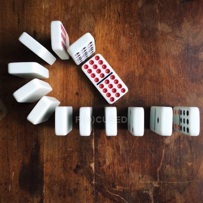 Row of dominos on a wooden table, top view — Stock Photo