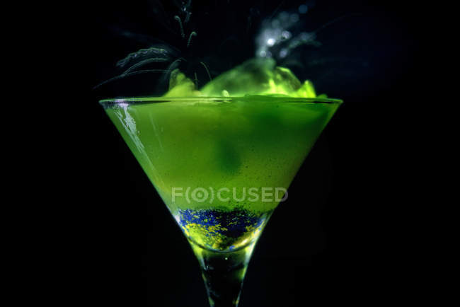 Bebida verde em um copo de coquetel, fundo preto — Fotografia de Stock