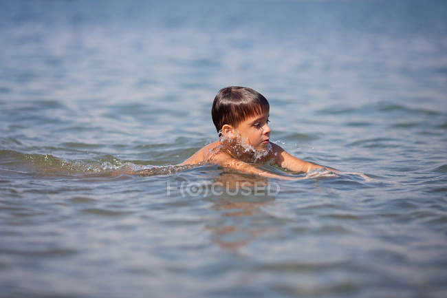 Маленький хлопчик плаває в морі влітку — стокове фото