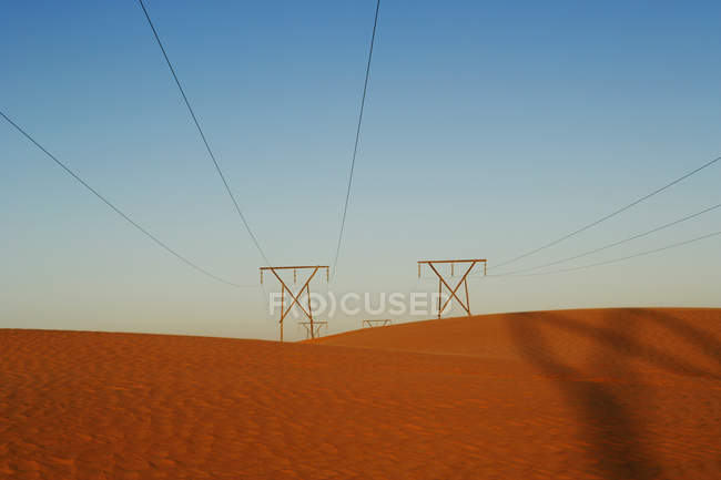Линии электропередач в пустыне против голубого неба, Намибия — стоковое фото