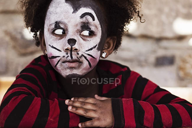 Niña con la cara pintada durante la temporada festiva del carnaval - foto de stock