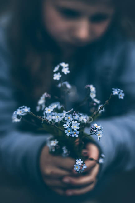 Nahaufnahme eines Mädchens mit einem Strauß Vergissmeinnicht-Blumen — Stockfoto