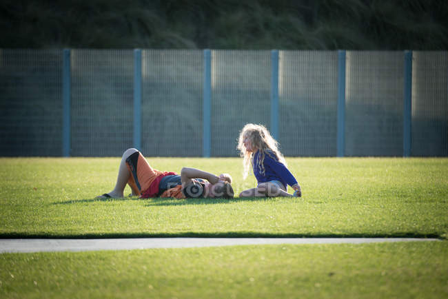 Menino e menina falando em um campo de futebol — Fotografia de Stock