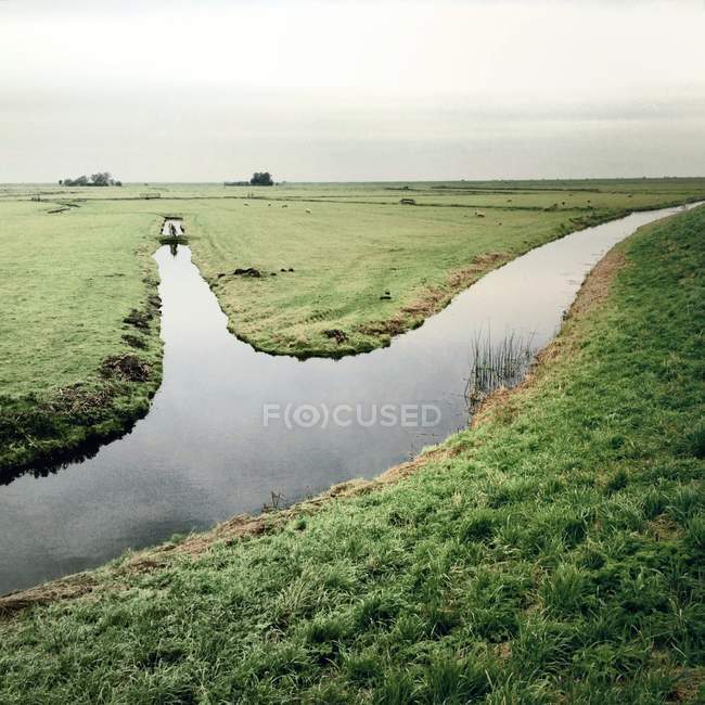 Vue panoramique du paysage avec rivière et champ — Photo de stock