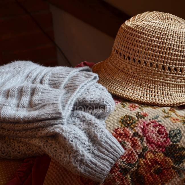 Vista de primer plano de suéter y sombrero en el sofá - foto de stock