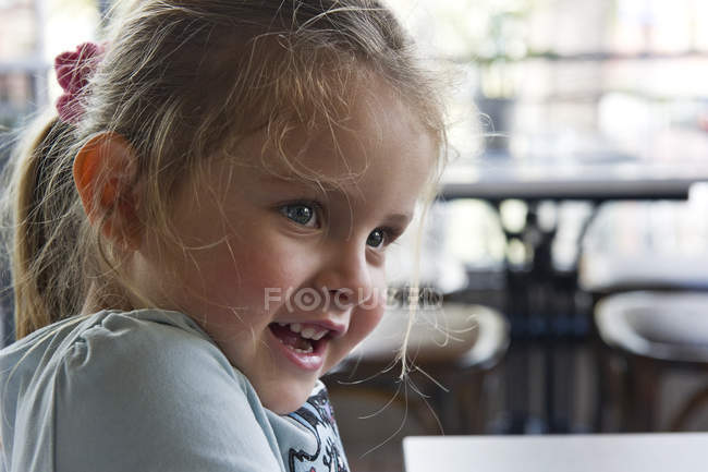 Retrato de una chica sonriente mirando hacia los lados - foto de stock
