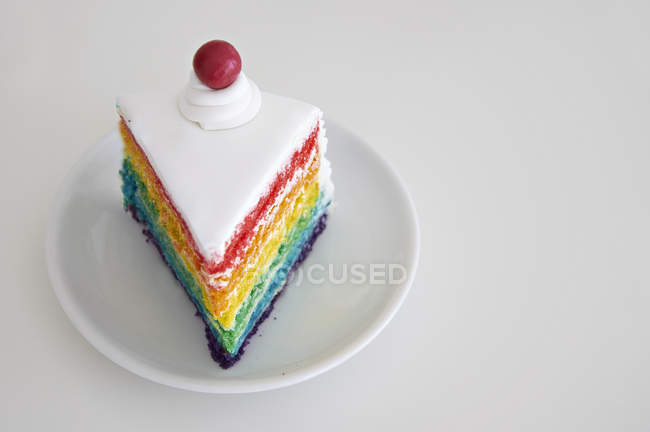 Nahaufnahme von einem Stück Regenbogenkuchen auf einem Teller — Stockfoto