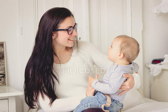 Щаслива мати обіймає маленького сина вдома — стокове фото