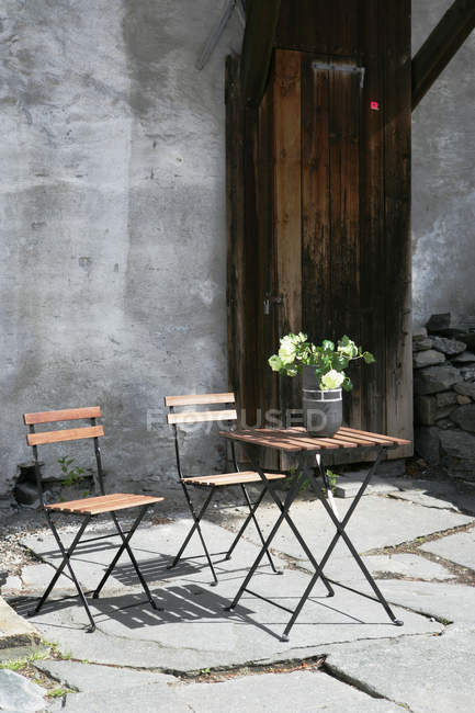 Cafétisch mit Blumen und Stühlen im Freien — Stockfoto