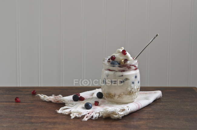 Yogurt parfait with granola and fresh berries against white wall — Stock Photo
