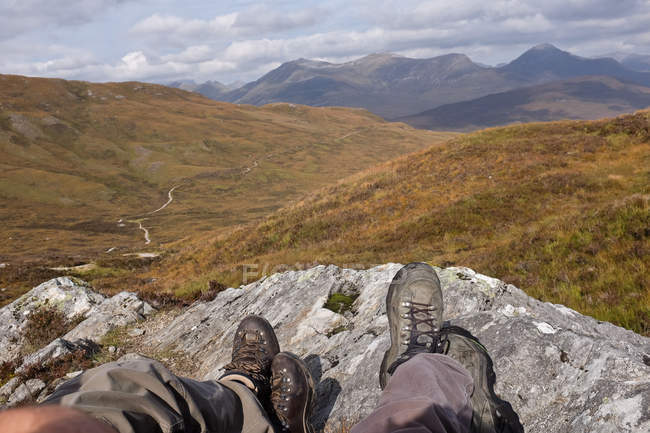 Обрізане зображення двох чоловіків, що сидять на каменях у горах — стокове фото