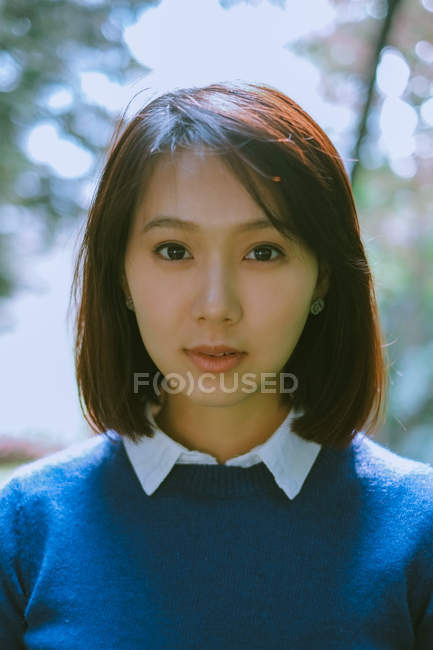 Close-up portrait of a beautiful brunette asian woman looking at camera — Stock Photo