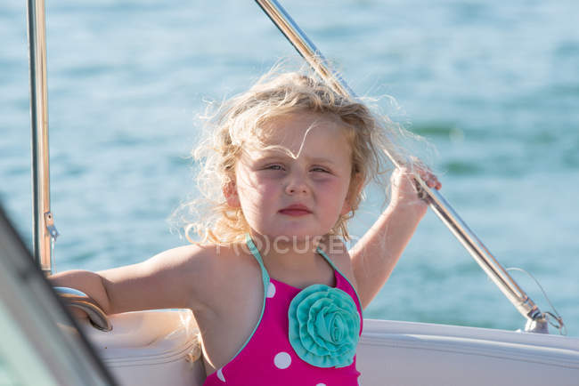 Little girl standing on a sailing boat and looking at camera — Stock Photo