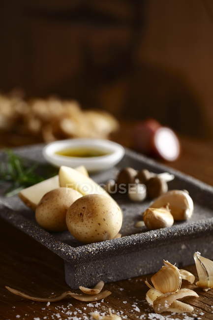 Картопля і часник з соусом в старовинній тарілці на столі — стокове фото