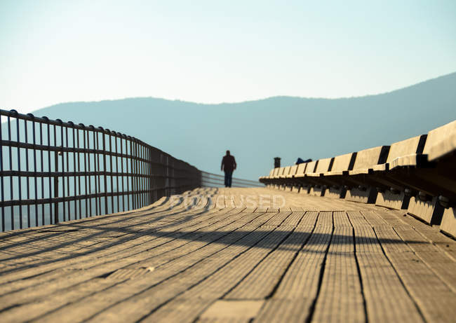 Grécia, Attica Periphery, Porto Rafti, Pessoa que atravessa a passarela de madeira — Fotografia de Stock