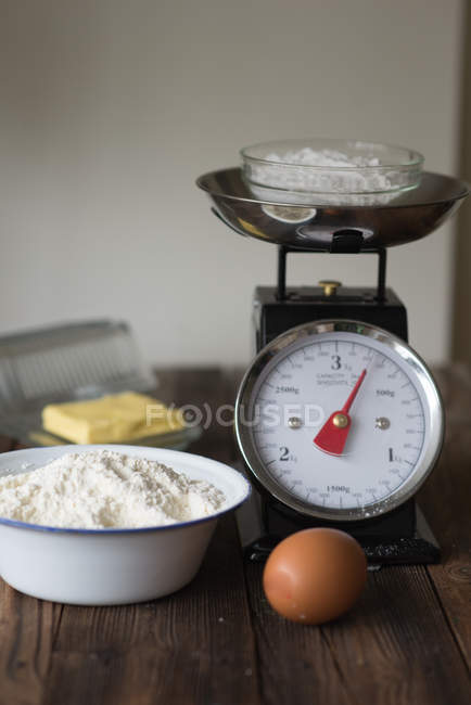 Выпечка ингредиентов на кухонном столе с чешуей, яйцом и мукой — стоковое фото
