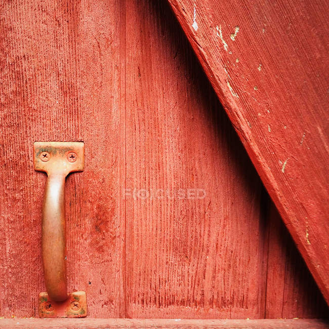 Punho de metal na porta de madeira vermelha, vista closeup — Fotografia de Stock
