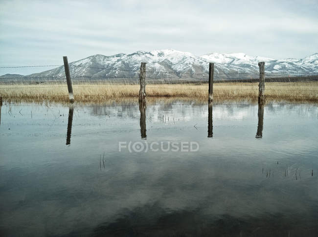 Vista panoramica di recinzione metallica che si riflette nel lago — Foto stock