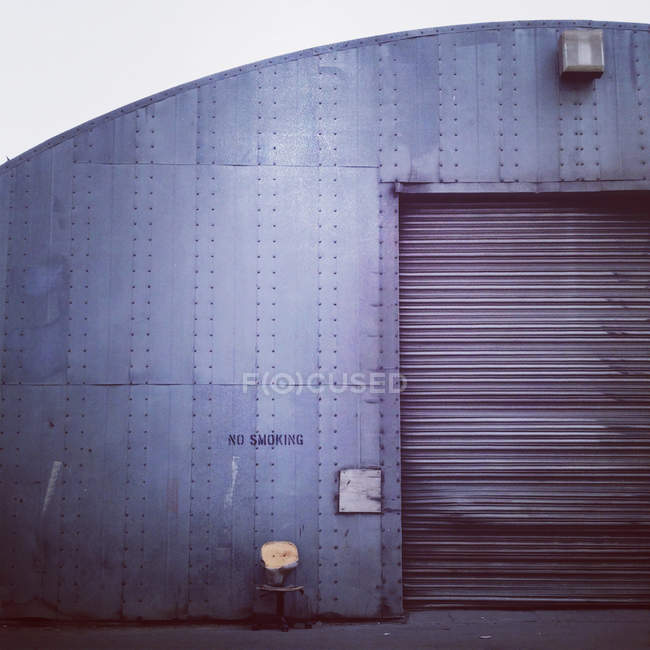 Sedia solitaria di fronte al capannone industriale — Foto stock