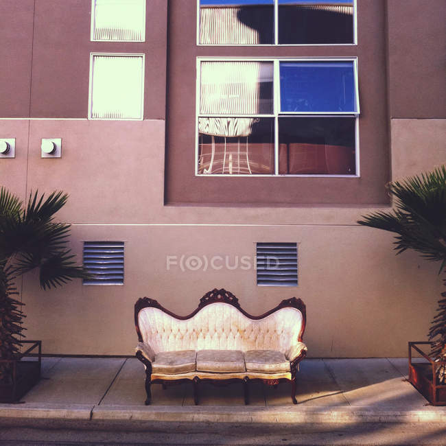 Vista panorâmica do sofá vintage na calçada contra a construção — Fotografia de Stock
