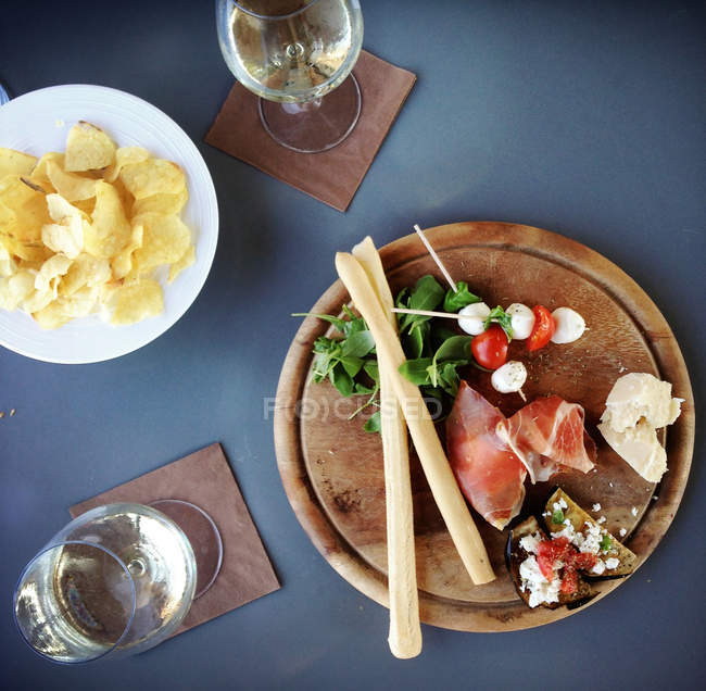 Вид сверху на ветчину, сыр, корм для пальцев пармиджаны и помидоры черри с сыром моцарелла — стоковое фото