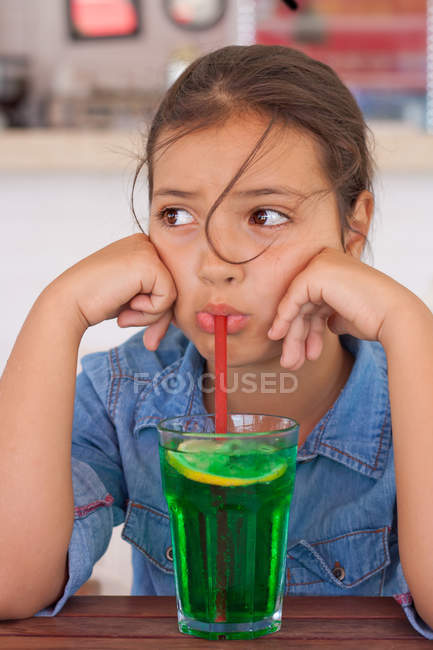 Grumpy menina bebendo mocktail através de uma palha — Fotografia de Stock