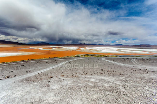 Bolivien, Altiplano, Landschaft mit bewölktem Himmel über roter Lagune — Stockfoto