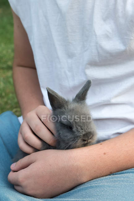 Close-up de Menino segurando um coelho no colo — Fotografia de Stock