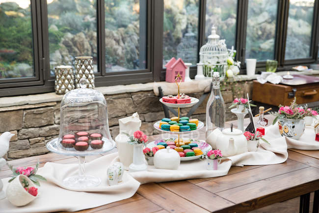 Tavolo in legno con dolci festivi deliziosi, tè e caffè — Foto stock