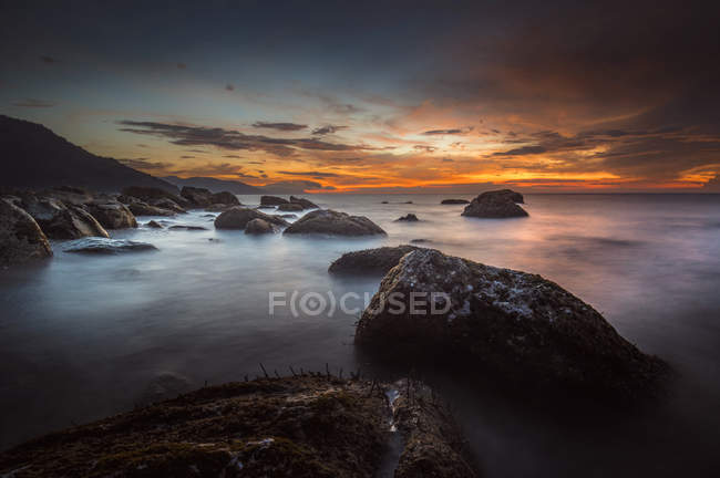 Vue panoramique sur le coucher du soleil sur la côte rocheuse — Photo de stock