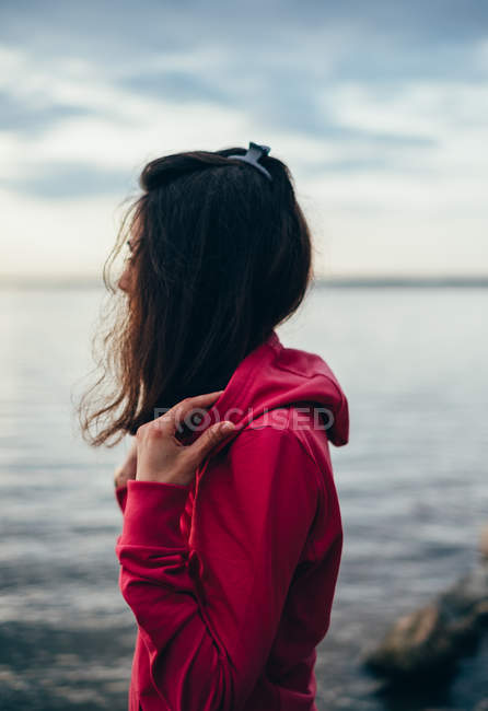 Frau, die auf See steht und die Aussicht betrachtet — Stockfoto