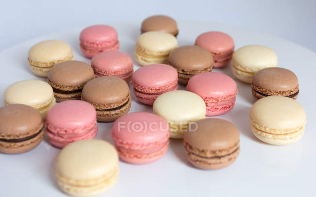 Strawberry, chocolate and vanilla macaroons on a plate — Stock Photo