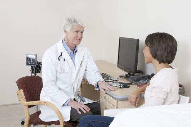 Arzt im Gespräch mit Patientin im Untersuchungsraum — Stockfoto