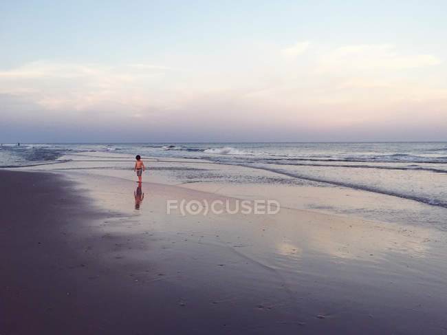 Junge, der in der Abenddämmerung am Strand entlang geht, Florida, Amerika, USA — Stockfoto