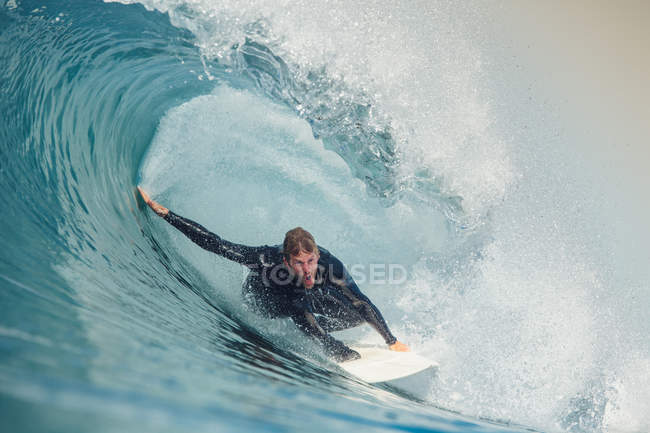 Hombre en tabla de surf en postura de perro cerdo, San Diego, California, América, EE.UU. - foto de stock