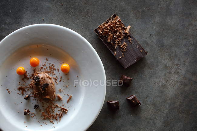Mousse di cioccolato su piatto e tavoletta di cioccolato su superficie grigia — Foto stock