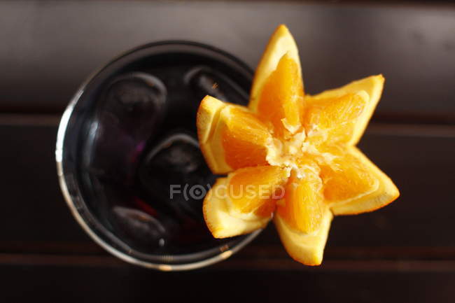 Top view of black cocktail with star shaped orange — Stock Photo