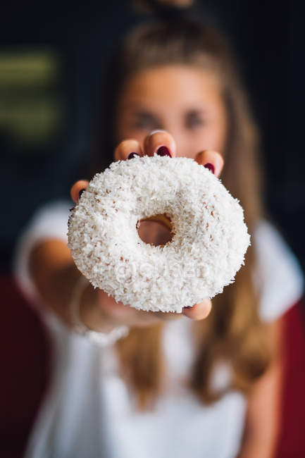 Красива молода жінка тримає солодкий смачний пончик — стокове фото