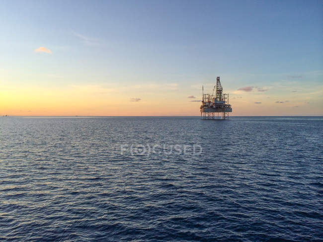 Vista panorâmica da plataforma de petróleo no belo pôr do sol — Fotografia de Stock