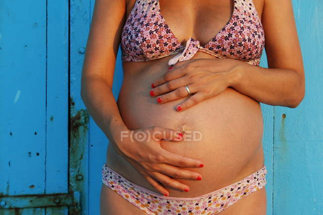 Imagen recortada de la mujer embarazada cuna del estómago - foto de stock