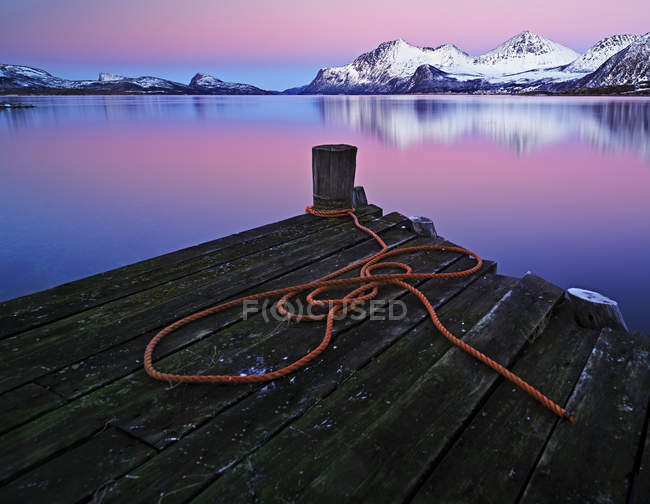 Snow covered mountains seen from a wooden jetty — Stock Photo