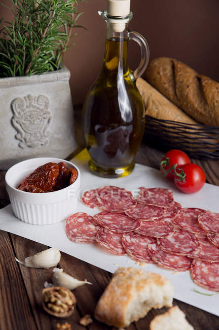 Salami, tomates séchées au soleil, pain et huile d'olive — Photo de stock