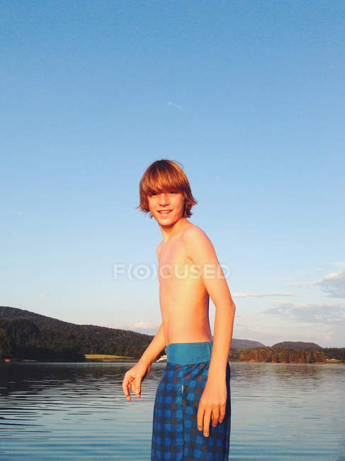 Портрет хлопчика, що стоїть на березі озера влітку — стокове фото