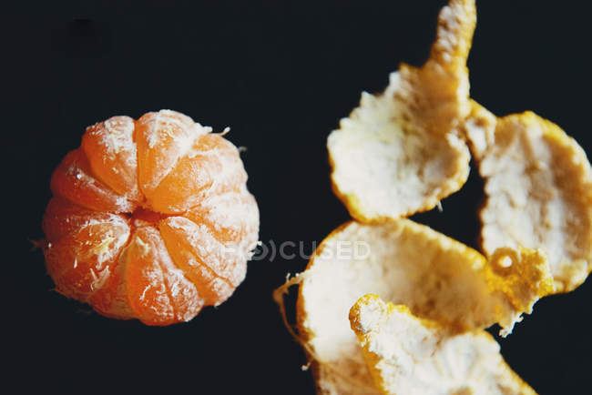 Close-up of fresh mandarin fruit without skin, black background — Stock Photo