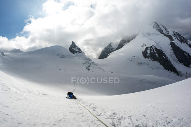 Mountain climber lying on snow in Swiss Alps, Piz Bernina, Switzerland — Stock Photo